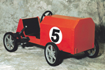 Children's wood coaster car is painted red with a racing number on the side